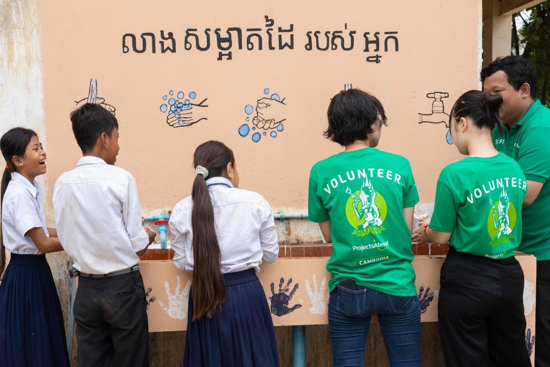 Des stagiaires en soins infirmiers au Cambodge montrent comment bien se laver les mains à des enfants